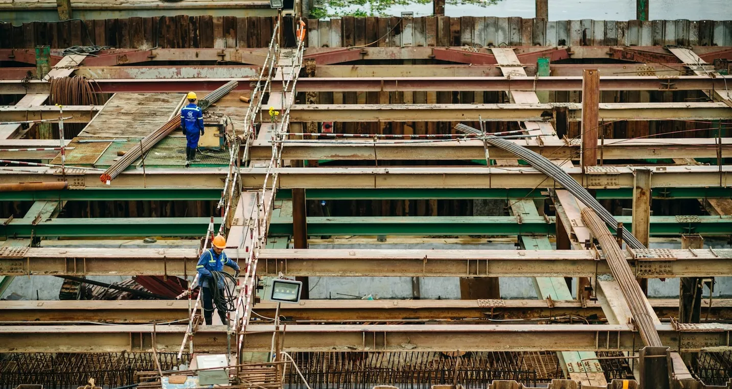 A group of construction workers working on a building site rooftop, surrounded by scaffolding and tools