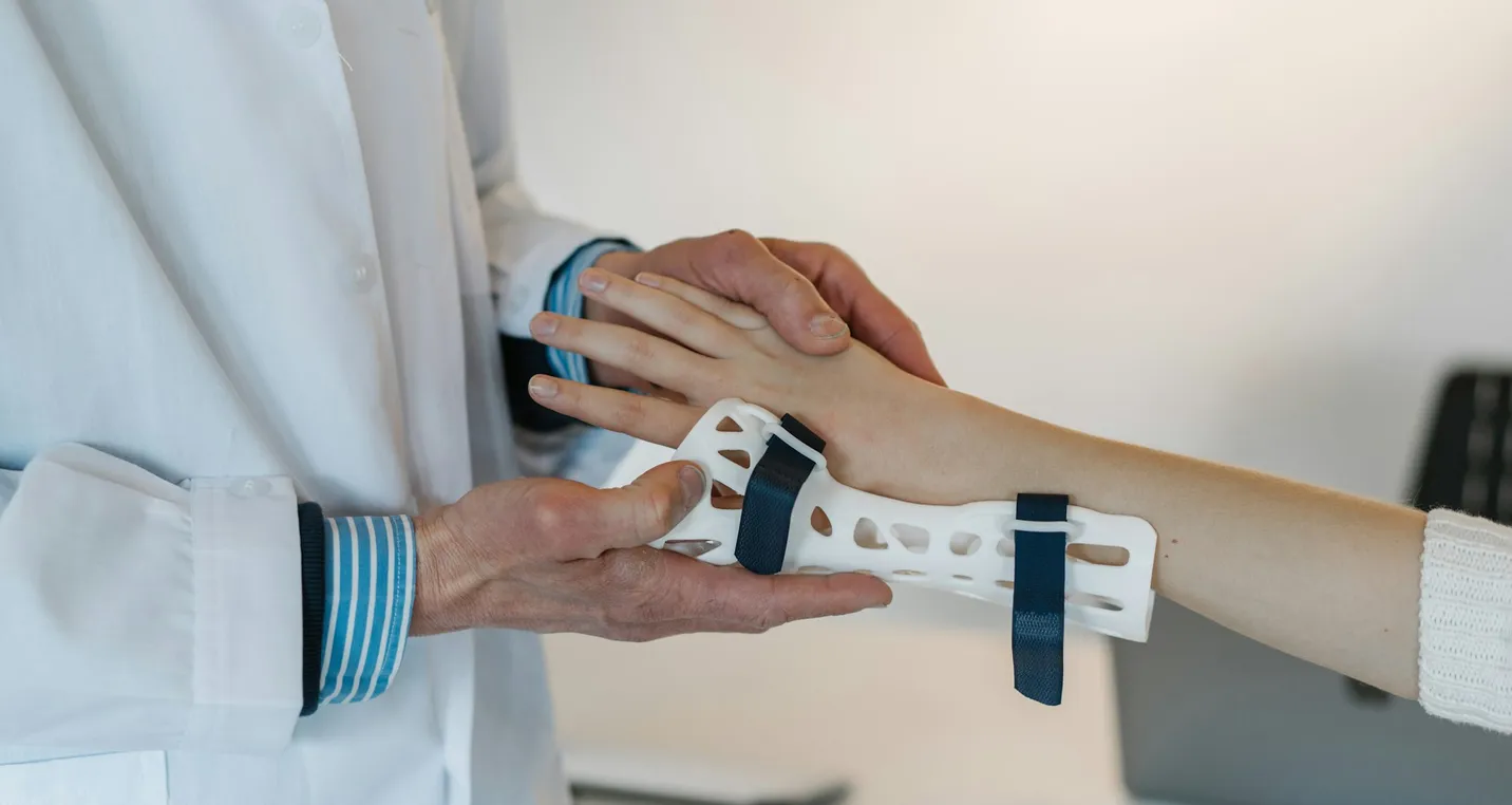 A doctor placing a a brace on a child with a hand injury.