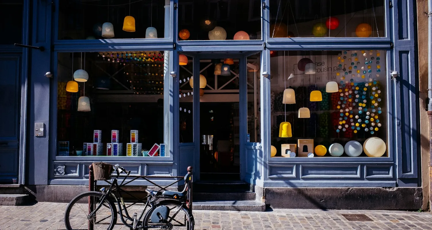 A small lighting store with a variety of lamps and lights on display with a blue bicycle in the foreground